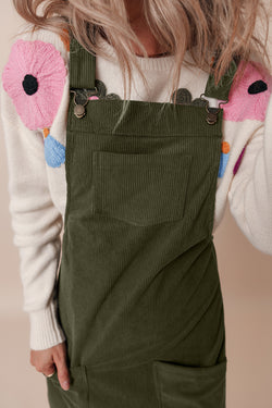 Sleeveless velvet overall dress with vineyard green pockets before