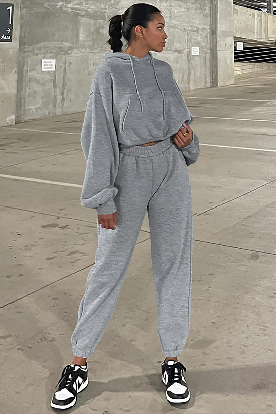 Set of plain gray sports clothes with hooded sweatshirt and jogging pants with falling shoulders