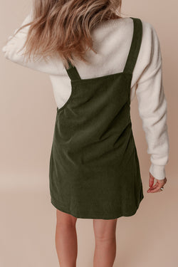 Sleeveless velvet overall dress with vineyard green pockets before