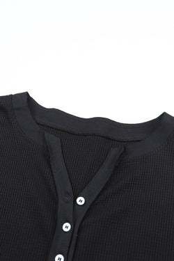 Alto Henley en tejido negro en relieve con un escote fronterizo