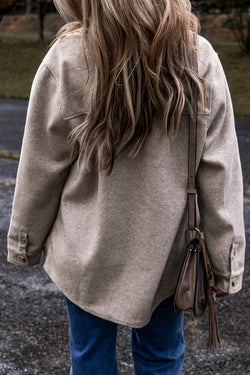 Chaqueta abotonada gris claro con cuello plegado y bolsillos de aleta