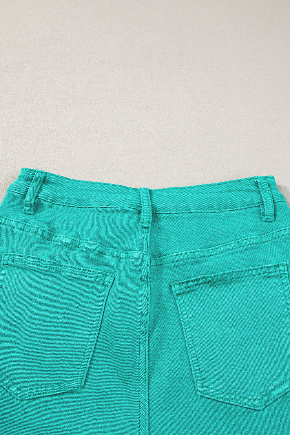 Mid-rise denim shorts with frayed edges in turquoise