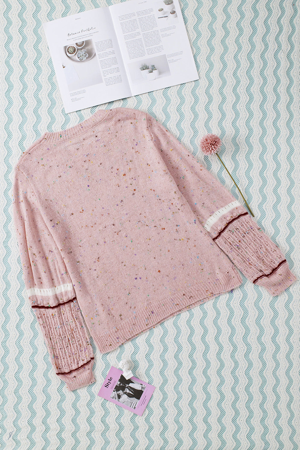 Pink sweater with patterned sleeves and pilled details