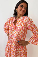 Mini-robe orange à imprimé floral et manches à volants boutonnée sur le devant