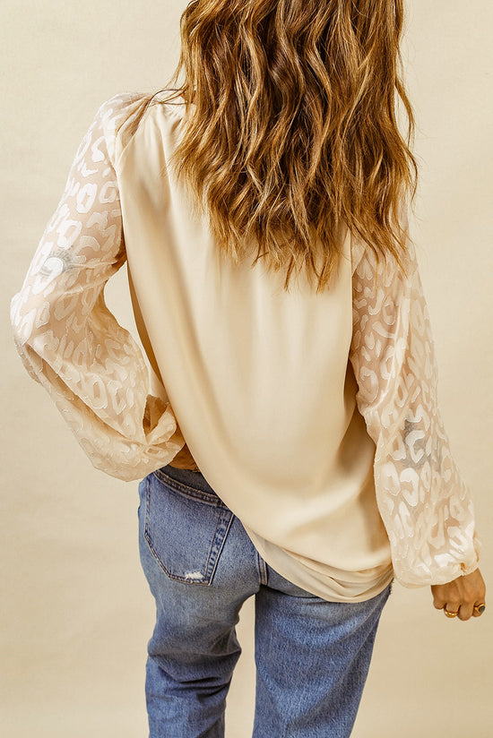 Blusa beige con cuello dividido y mangas hinchadas en malla de leopardo