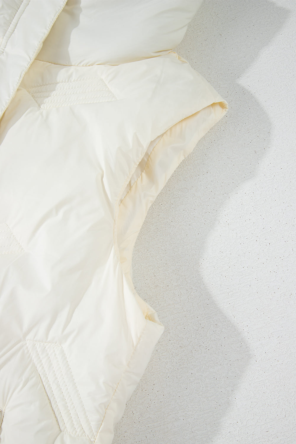 White quilted jacket with high collar and zipper