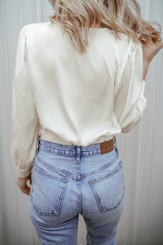 Short white blouse in V -neck and twisted elastic hem