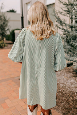 Green dress with plated and buttoned pockets *