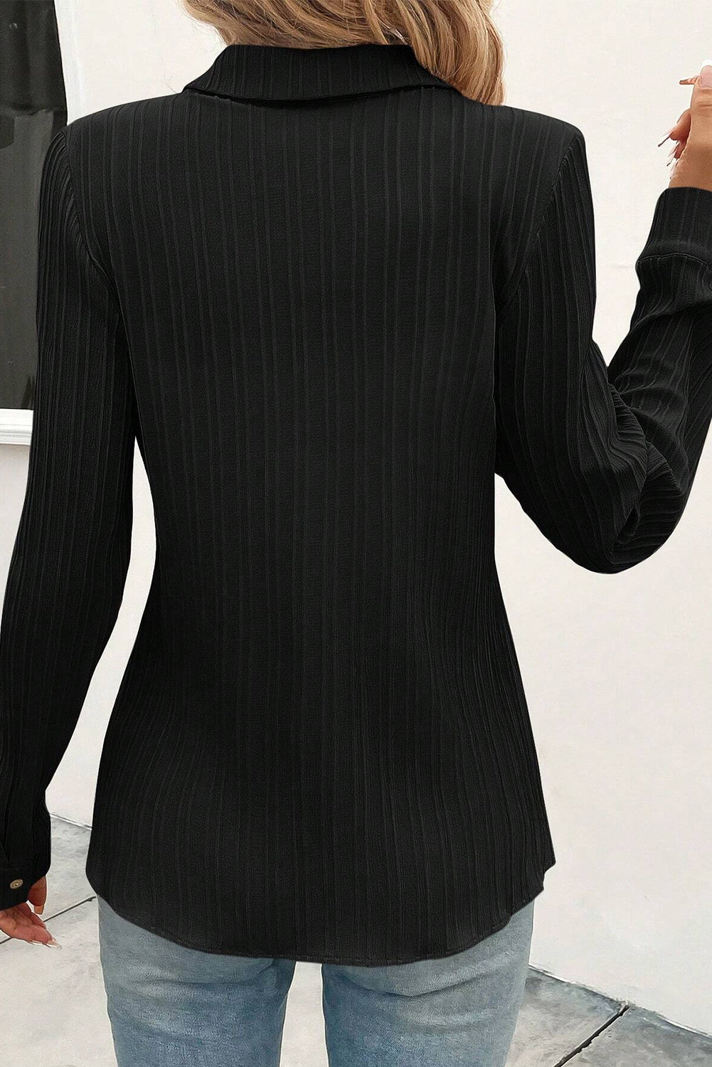 Chemise noire à col rabattu et boutonnée texturée de couleur unie