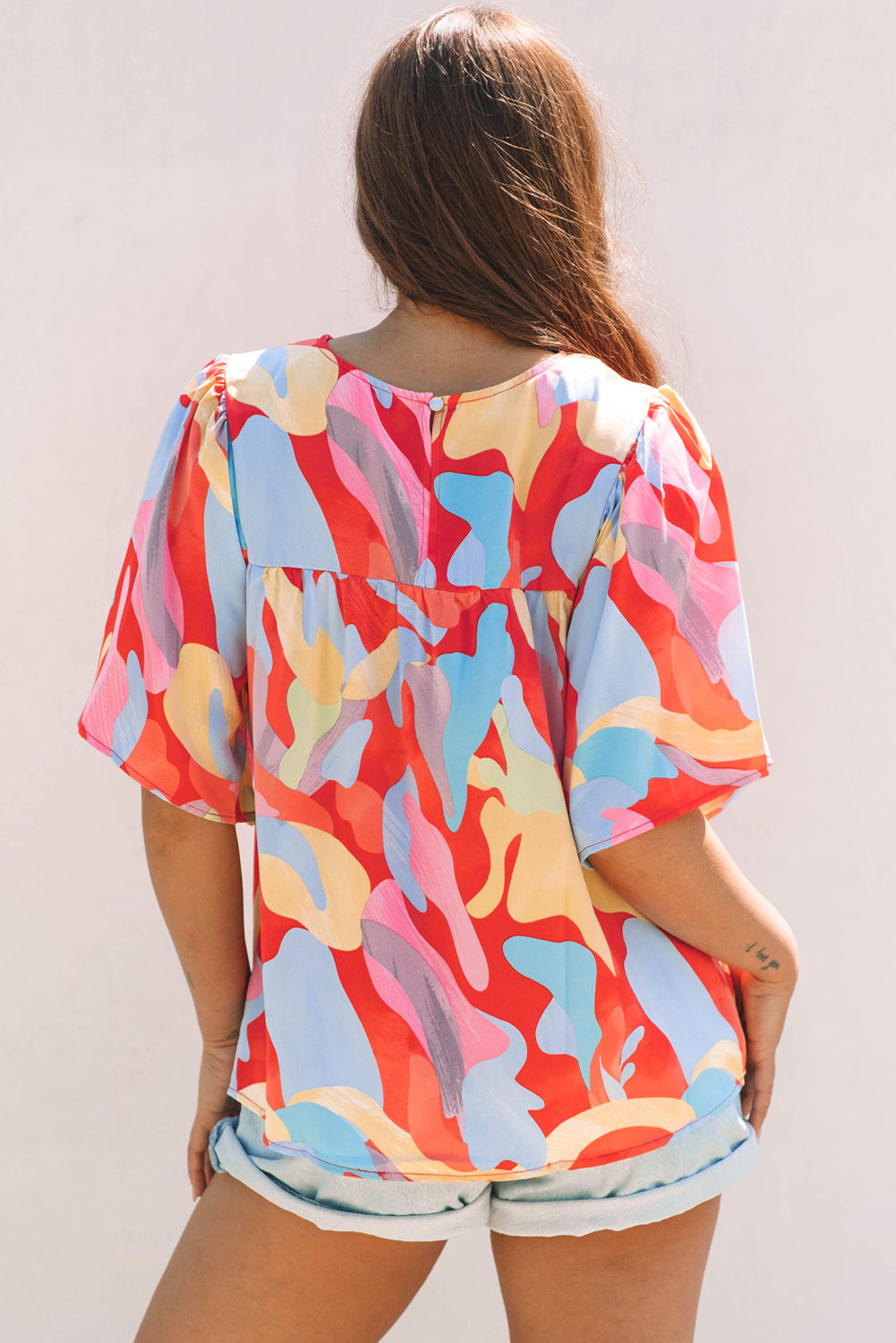 Blusa multicolor con cuello y mangas anchas con un patrón abstracto