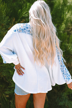 White blouse with bat handles and V-collar with abstract floral pattern