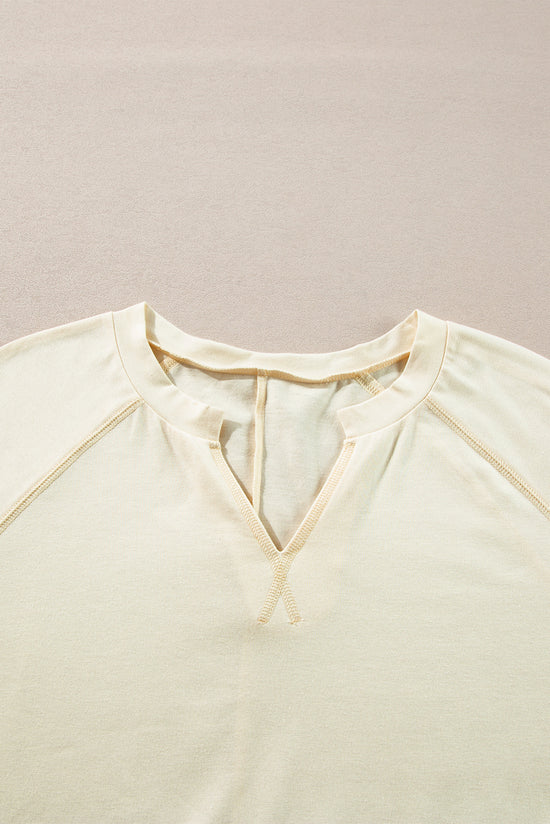 Apricot long sleeve top with notched neckline and exposed seams