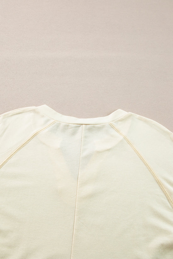 Apricot long sleeve top with notched neckline and exposed seams