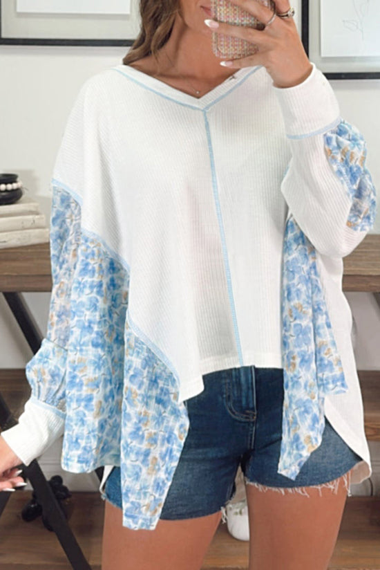 White blouse with bat handles and V-collar with abstract floral pattern