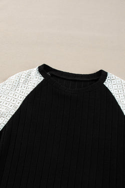 Black ribbed blouse with long sleeves and floral patchwork