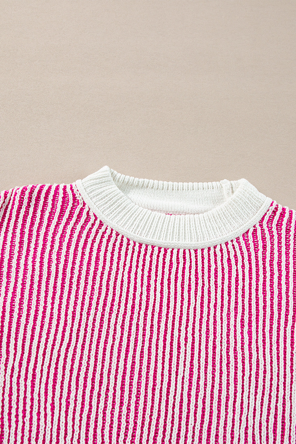 Loose-fitting sweater with contrasting edges in a textured knit with bright pink stripes