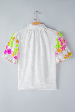 Textura blanca alta con cuello con cañón y flores de lentejuelas y mangas hinchadas