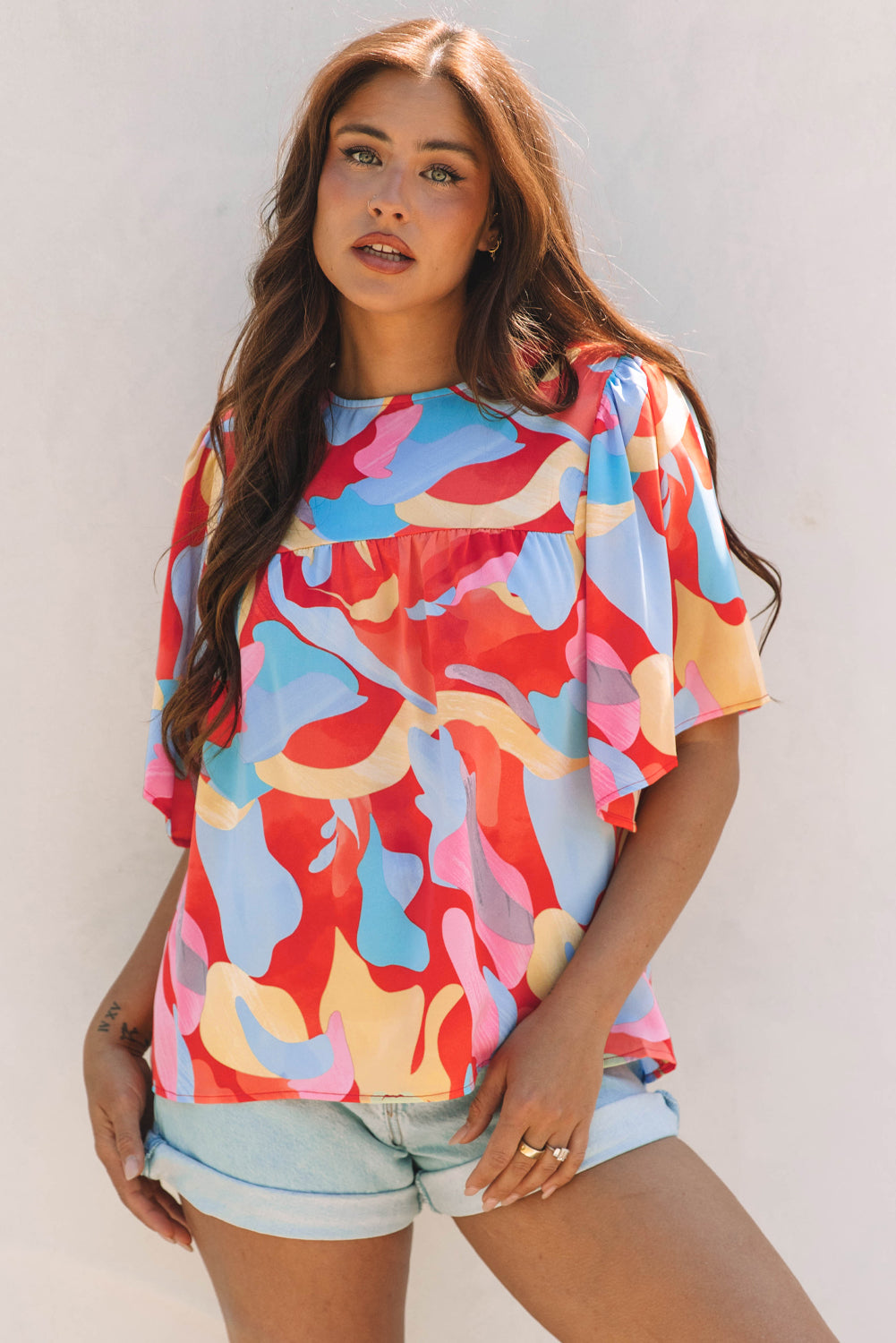 Blusa multicolor con cuello y mangas anchas con un patrón abstracto