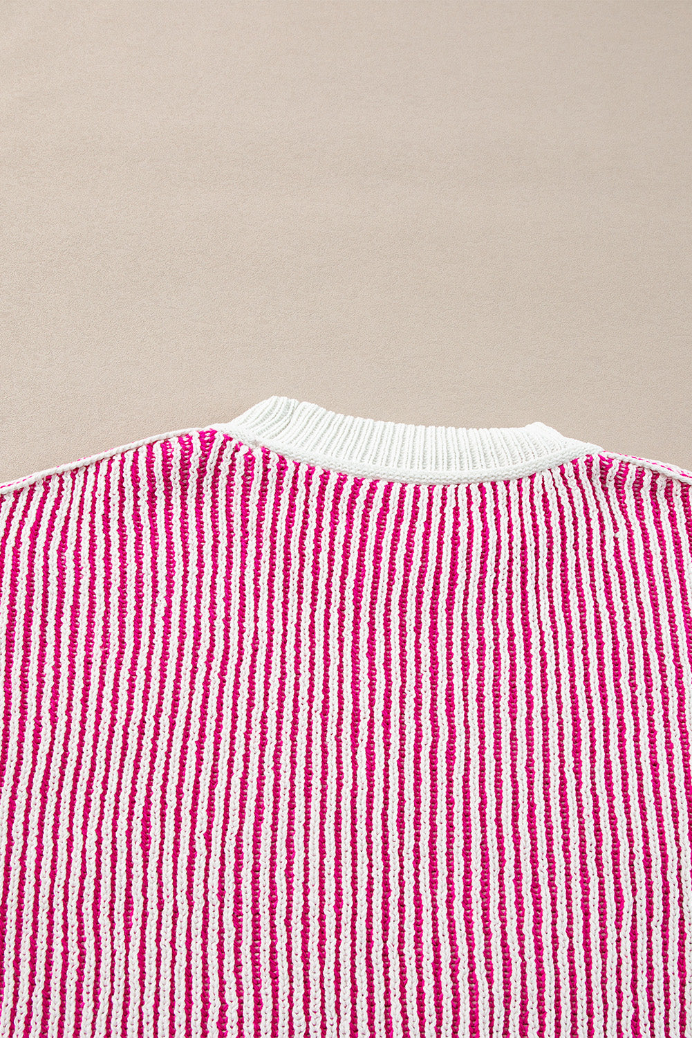 Loose-fitting sweater with contrasting edges in a textured knit with bright pink stripes