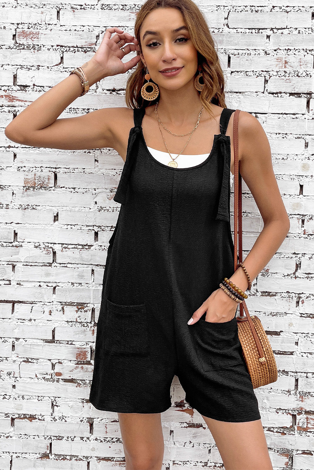 Black textured romper with adjustable straps and pockets