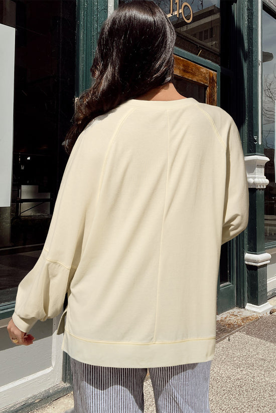 Apricot long sleeve top with notched neckline and exposed seams