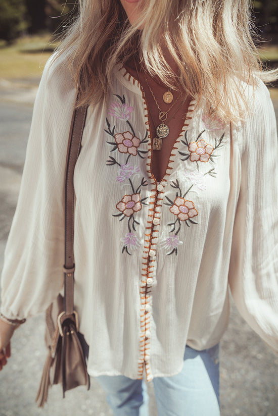 Beige loose shirt with puffy textured sleeves embroidered with flowers