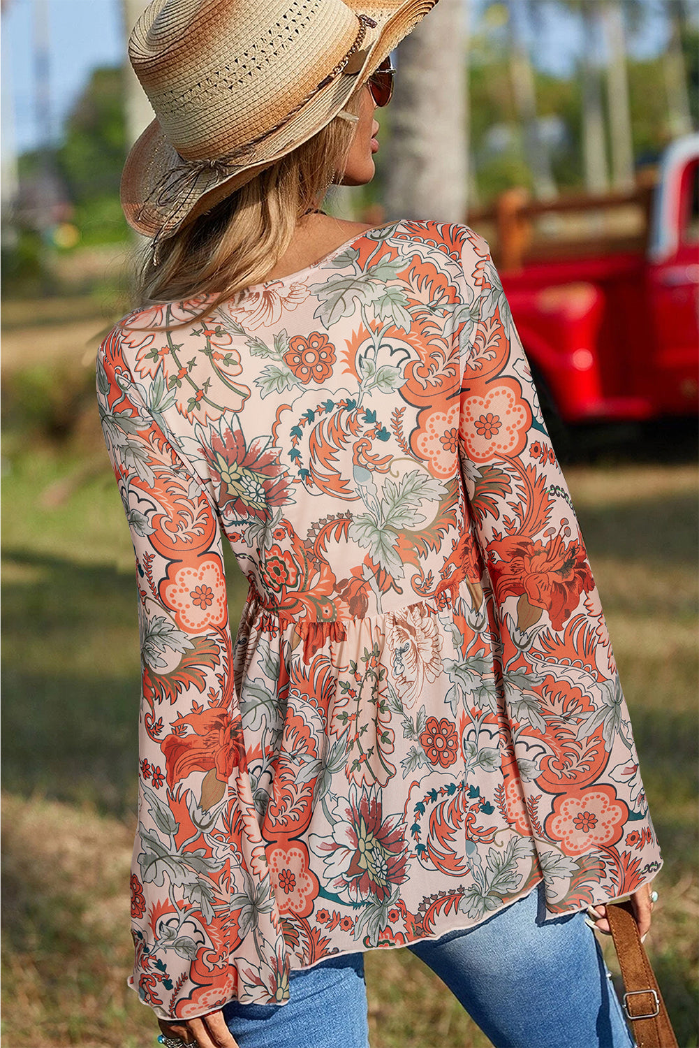 Blusa naranja con estampado floral y en v -neck con nudo y mangas de campana