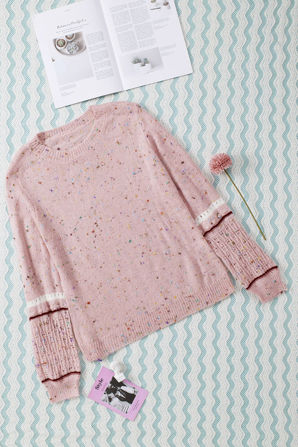 Pink sweater with patterned sleeves and pilled details