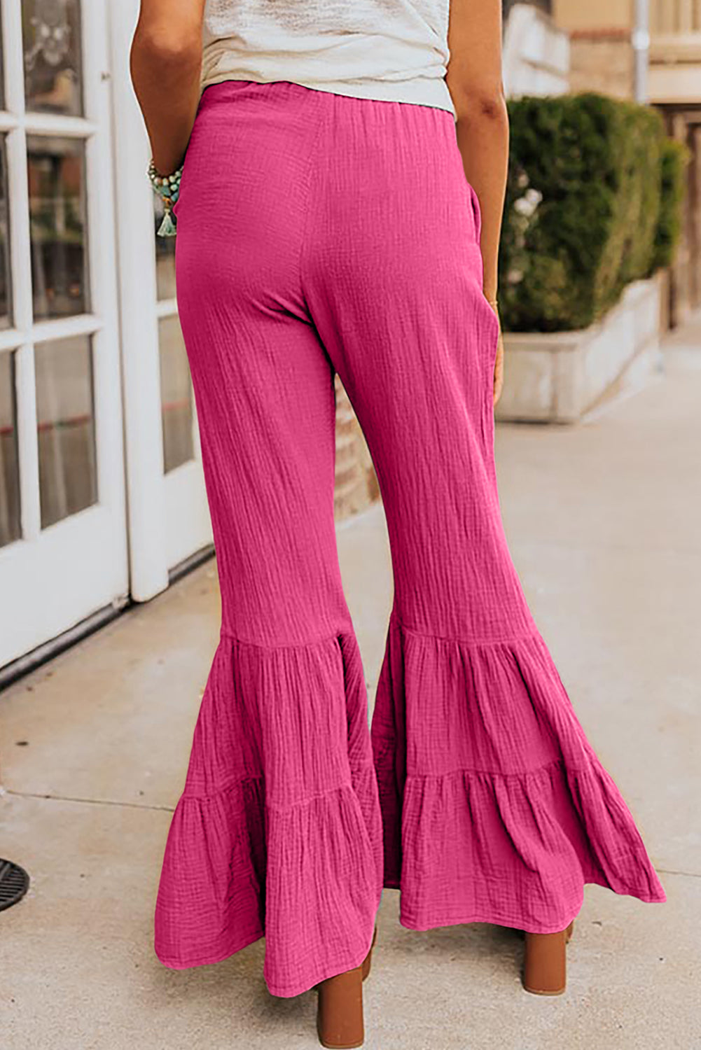 Pantalones acampanados con volantes y cintura alta con textura rosa