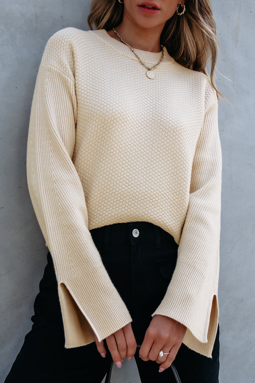 Loose-fitting parchment textured knit sweater with slit cuffs and dropped shoulders