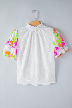 Textura blanca alta con cuello con cañón y flores de lentejuelas y mangas hinchadas