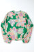 Large folded shirt with puffy sleeves and green floral print button