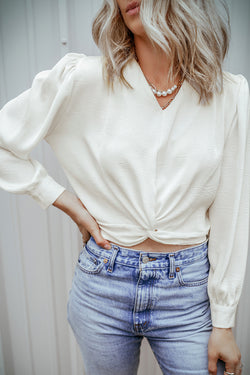 Short white blouse in V -neck and twisted elastic hem