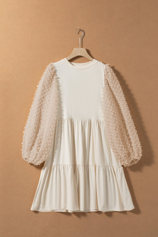 Beige trapeze dress adorned with puffy sleeves and several levels