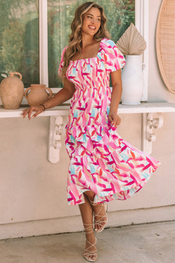 Smocked pink dress with ruffles and brush kick print