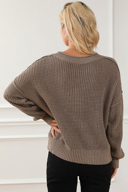 Khaki tricot sweater buttoned with V -neck button and drooping shoulders