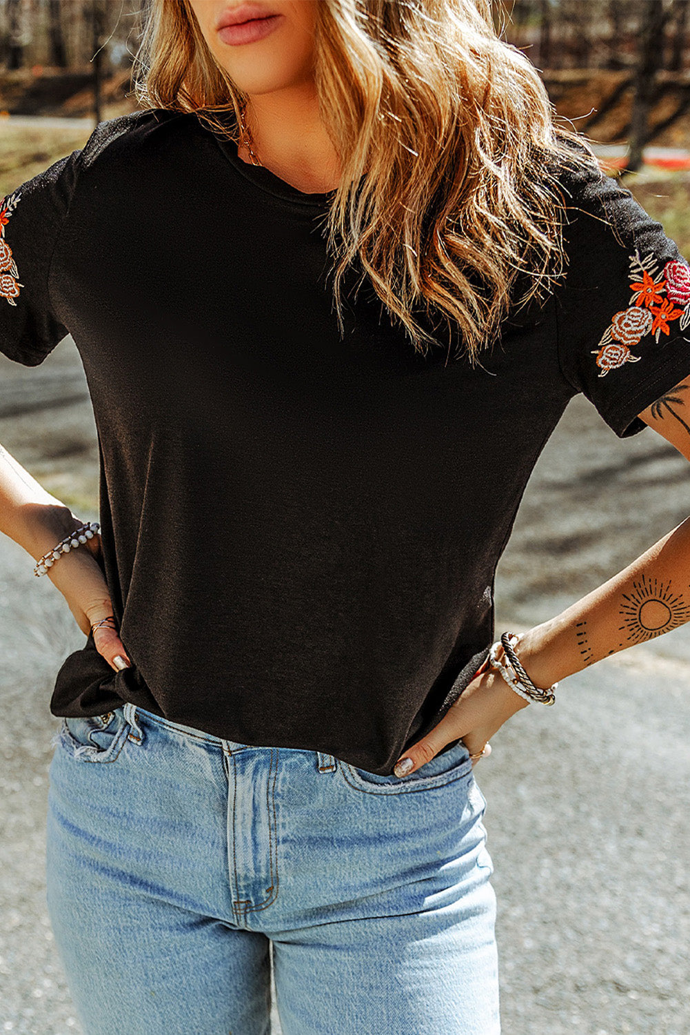 Black T-shirt with short sleeves and round neck embroidered with flowers