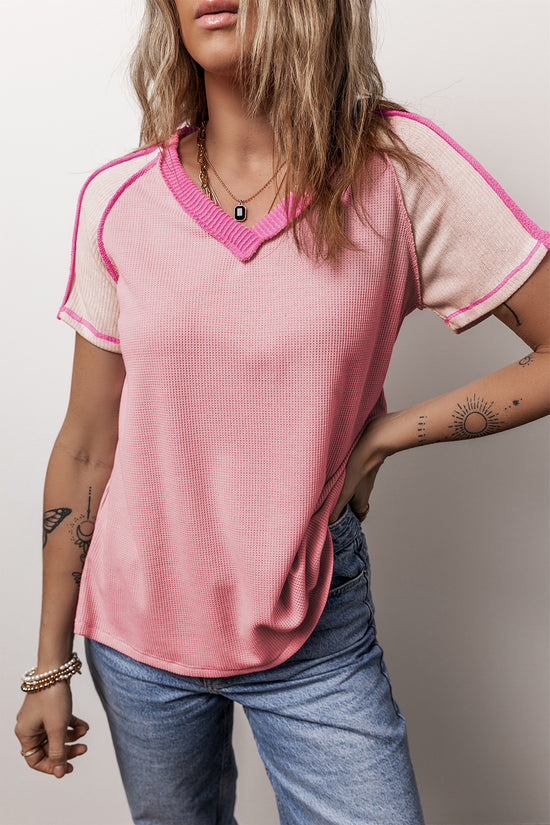 Camiseta rosa con cuello en V y costuras expuestas