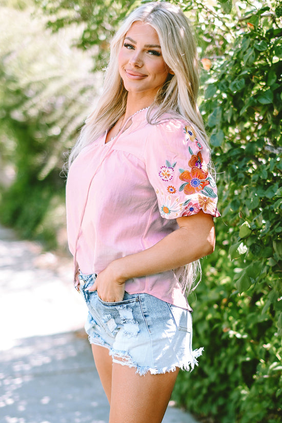 Blusa rosa con flores bordadas y mangas hinchadas, cuello dividido