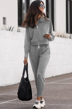 Salón con capucha gris con cable apretado y pantalones con alto contenido