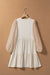 Beige trapeze dress adorned with puffy sleeves and several levels