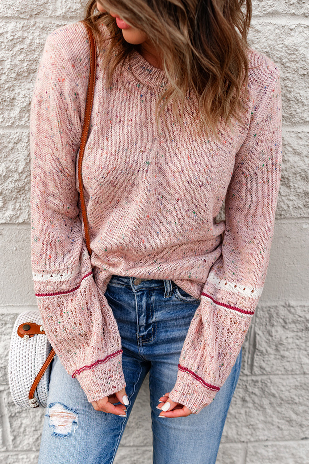 Pink sweater with patterned sleeves and pilled details