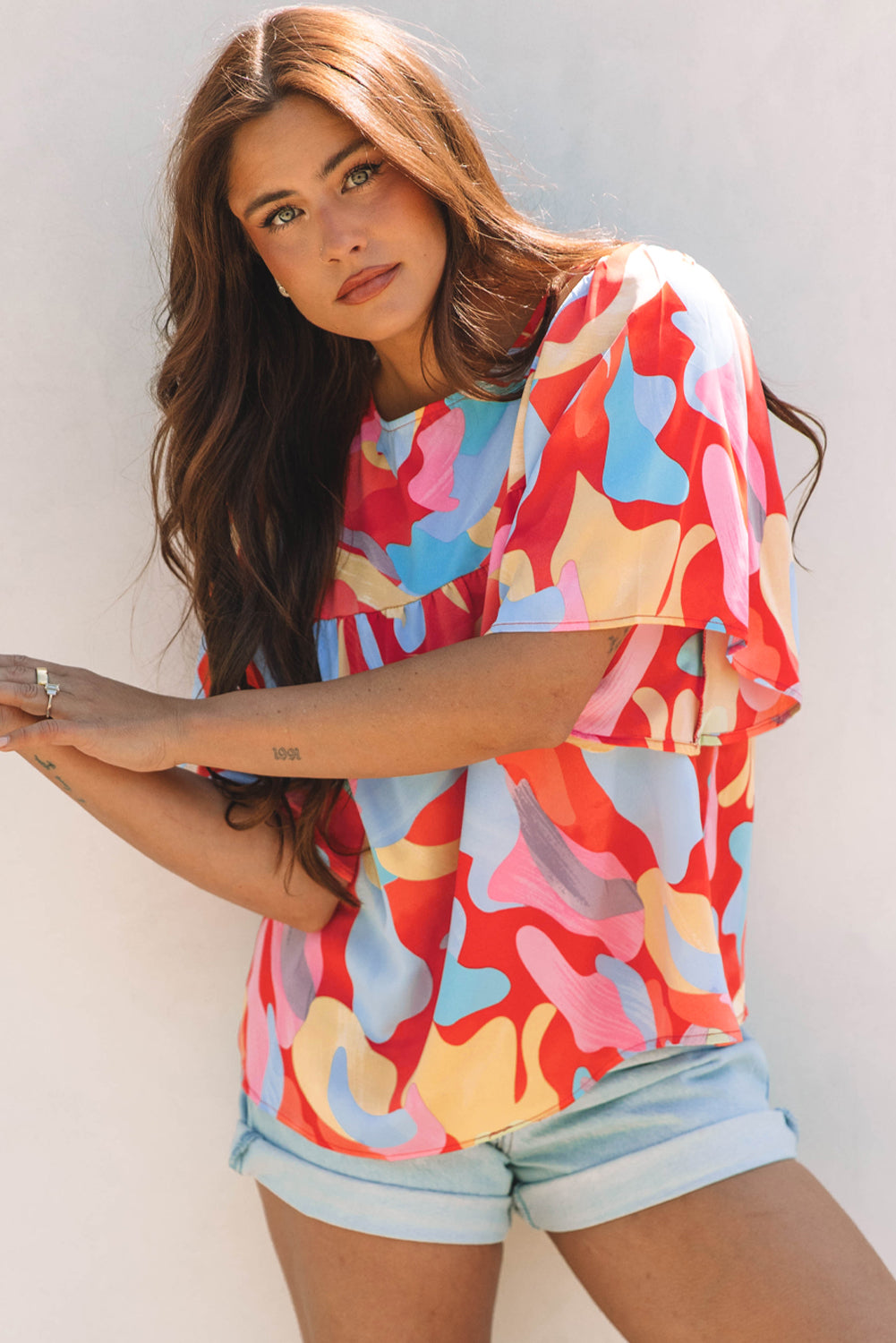 Blusa multicolor con cuello y mangas anchas con un patrón abstracto