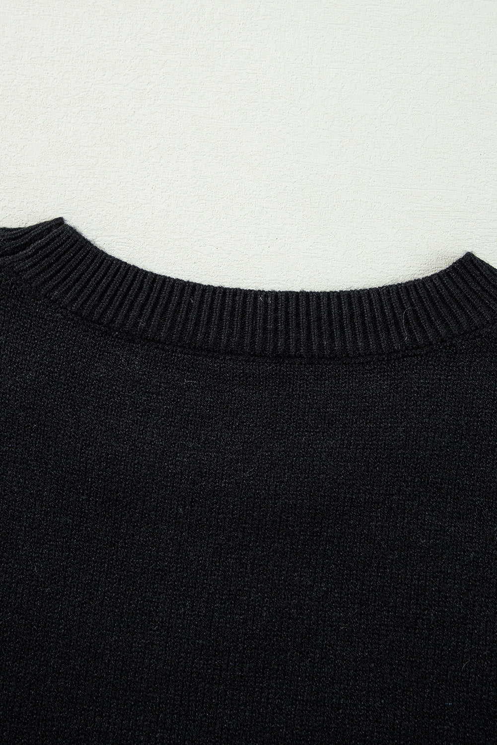 Black sweater with drooping shoulders and ribbed edges with Boo knitted pattern