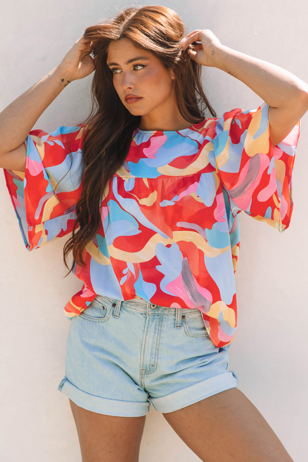 Blusa multicolor con cuello y mangas anchas con un patrón abstracto