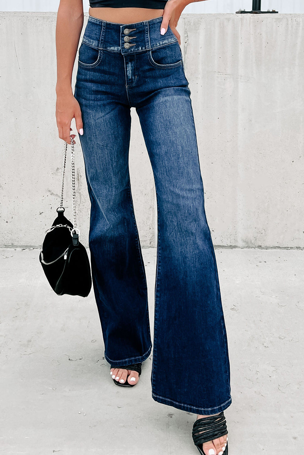 Pulsanti blu jeans flare con la cintura elastica elastica