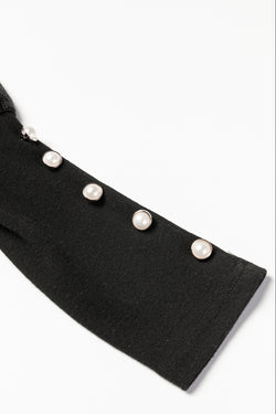 Black top with puffed sleeves and buttoned cuffs