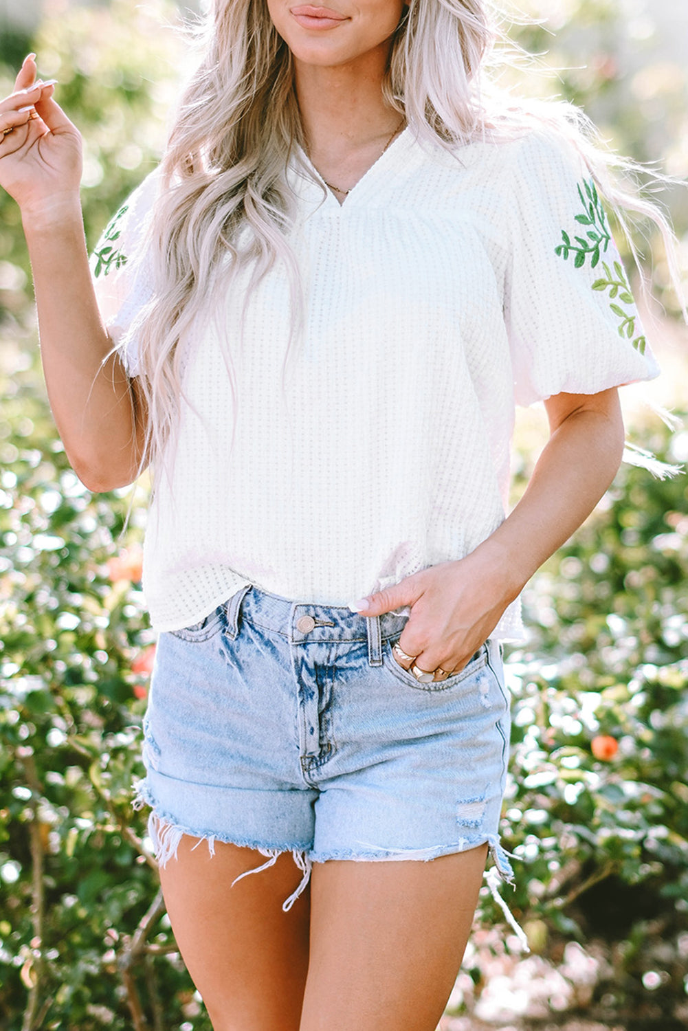 Blouse blanche à col cranté et manches bouffantes brodées de fleurs