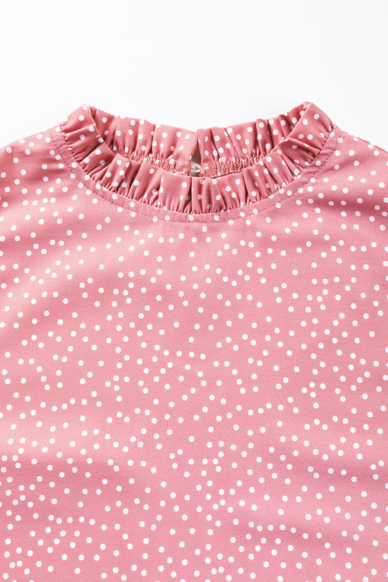 Blouse rose à pois et volants à manches flottantes et col à volants