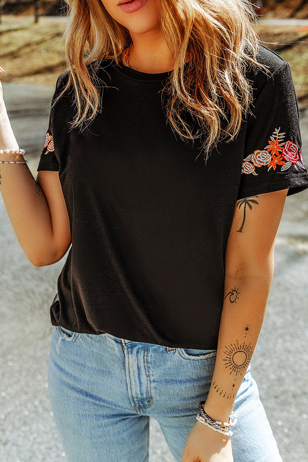 Black T-shirt with short sleeves and round neck embroidered with flowers